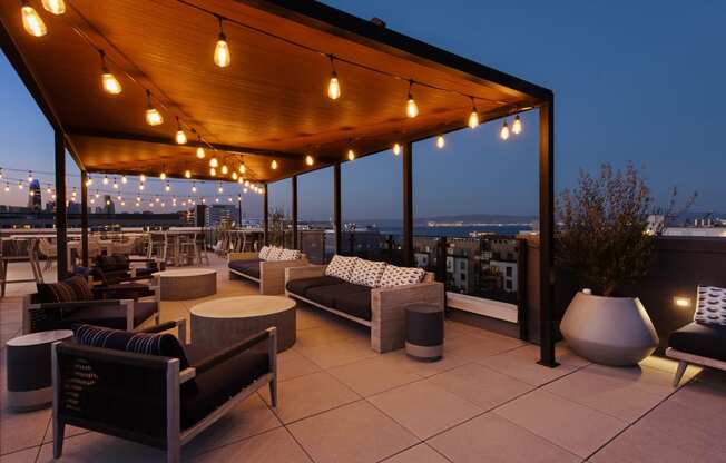 a roof top patio with chairs and tables and lights