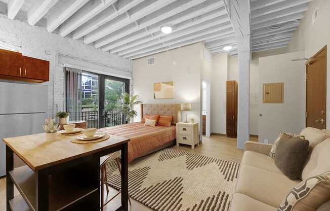 A well-lit, spacious bedroom with a large bed and a dining table.
