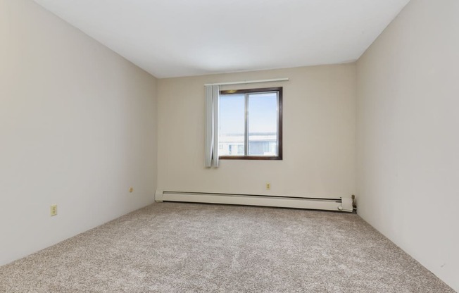 an empty room with a window and carpeting. Roseville, MN Rosedale Estates