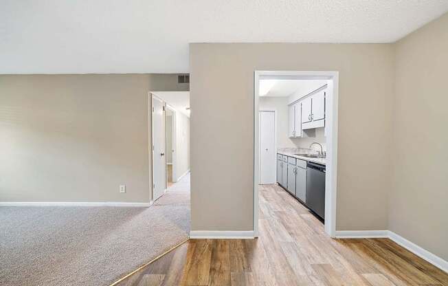 A kitchen area with a dishwasher and cabinets is visible through an open doorway.