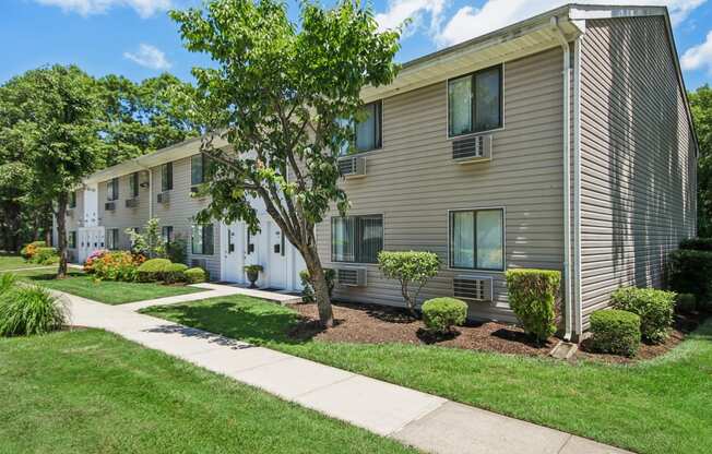 Outside view of apartment with a sidewalk and trees in front