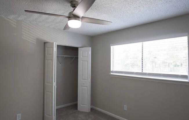 A room with a ceiling fan and a window with blinds at The Madison Apartments and Townhomes, Georgia 30044