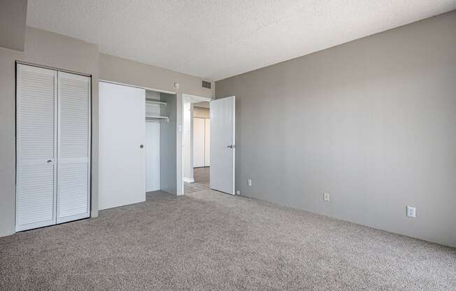 an empty living room with white walls and a closet