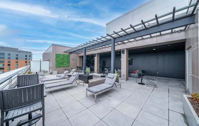 A rooftop patio with a table and chairs.