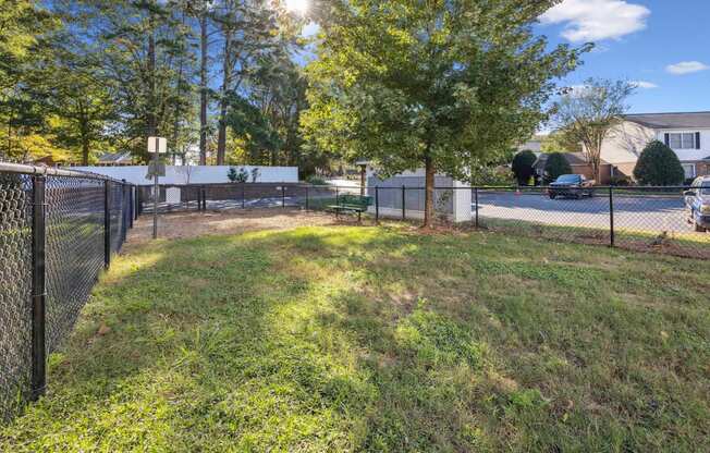 a fenced in yard with trees and a chain link fence