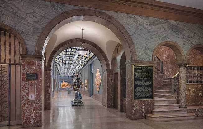 A long hallway with arches and a statue in the middle.