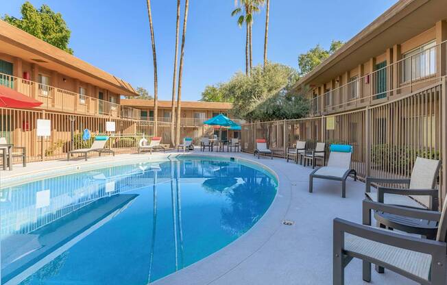 A pool surrounded by chairs and umbrellas.