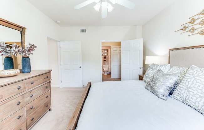 a bedroom with a bed and a dresser and a ceiling fan