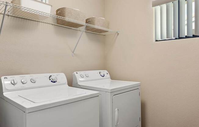 A white washing machine and dryer in a small laundry room.