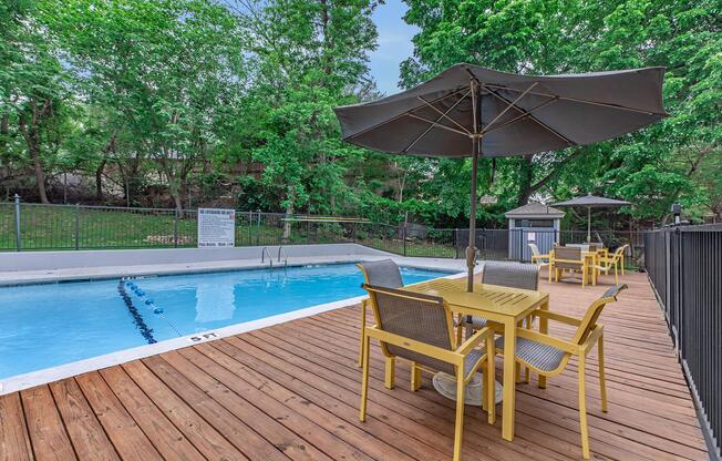 a couple of lawn chairs sitting next to a pool of water