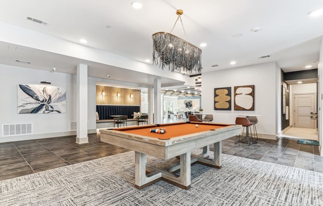 a pool table in a clubhouse with a chandelier