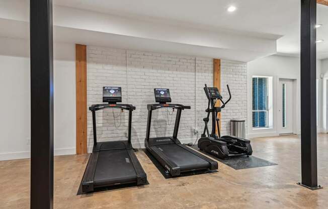 A gym with treadmills and elliptical machines.
