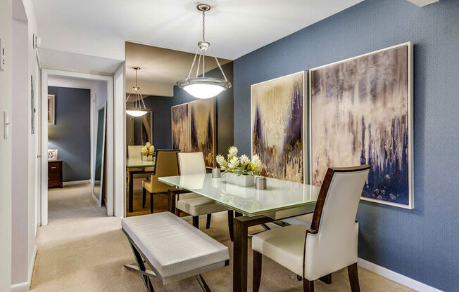 a dining room with a glass table and chairs
