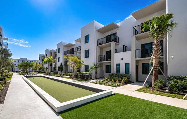 A white building with a green lawn in front.