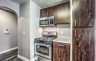 A kitchen with a stove top oven and microwave above it.