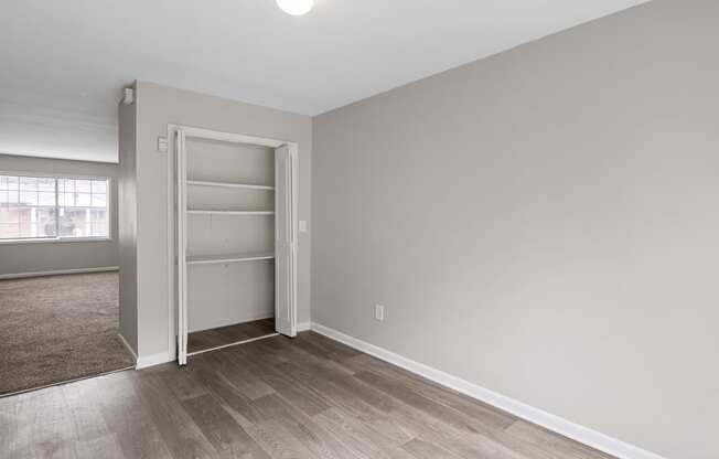 an empty bedroom with a closet and a window