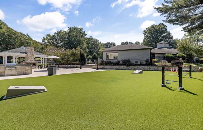 a putting green with a house in the background at View at Lake Lynn, Raleigh