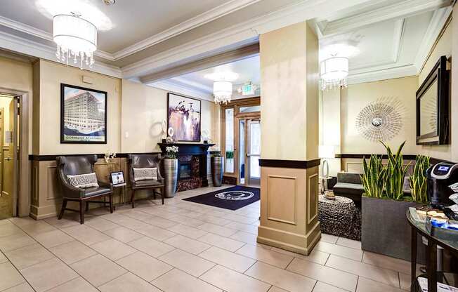 Apartment lobby with chairs and a fireplace.