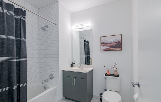 a white bathroom with a shower and a sink and a toilet