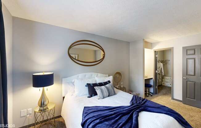 a bedroom with a large bed and a bathroom with a closet