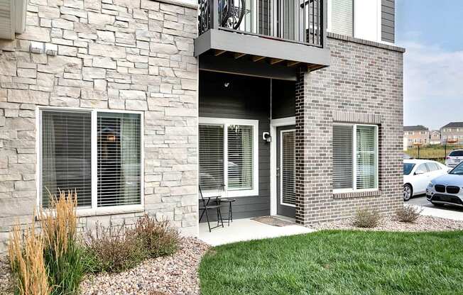 A house with a balcony and a car parked in front.
