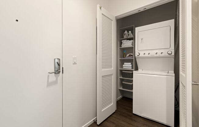 A white door with a handle and a white washing machine in a small laundry room.