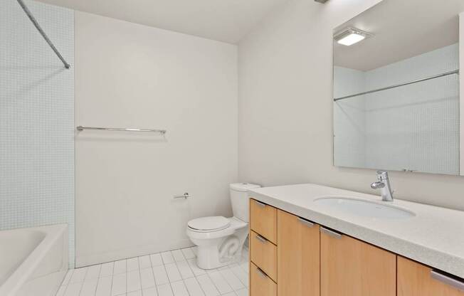 A white bathroom with a toilet, sink, and bathtub.