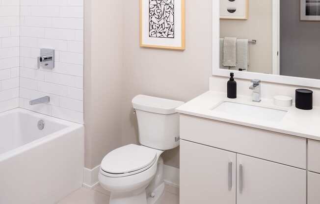 A white toilet sits next to a white sink in a bathroom.
