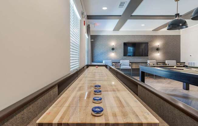 a bowling alley in a game room with a table with balls on it