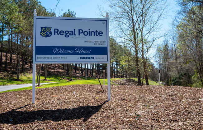 A blue and white sign welcoming people to Regal Pointe.
