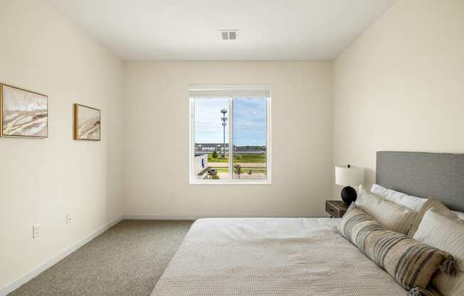 a bedroom with a large bed and a window at The Standard on 32nd, West Fargo, North Dakota