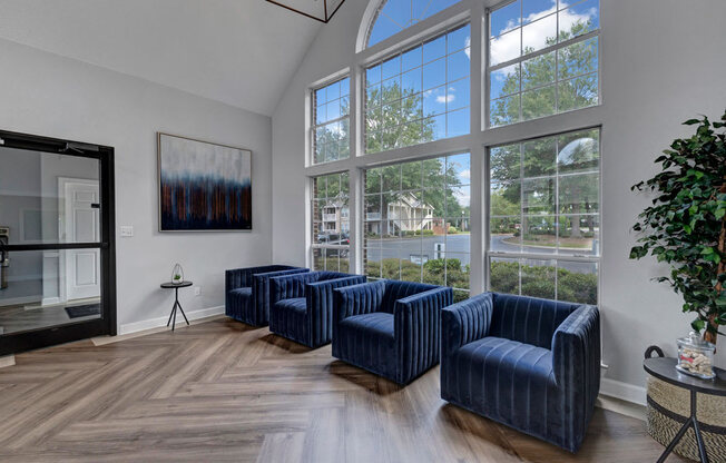 a waiting room with blue chairs and large windows