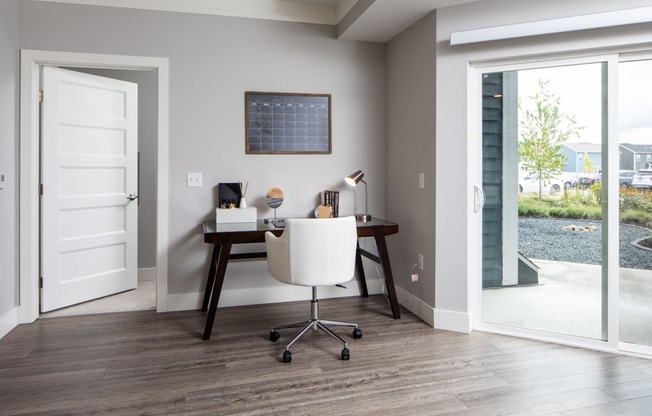 A room with a desk and a chair in it.