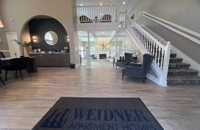 a living room with a rug and a staircase