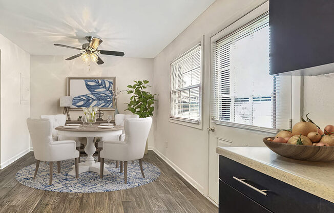 a dining room with a table and chairs and a ceiling fan