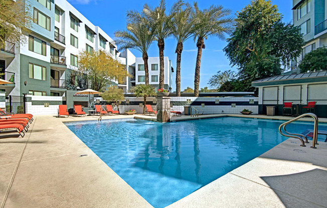 a swimming pool with an apartment building in the background