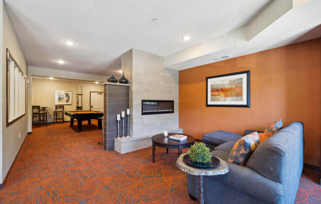 a living room with a couch and a table with a fireplace