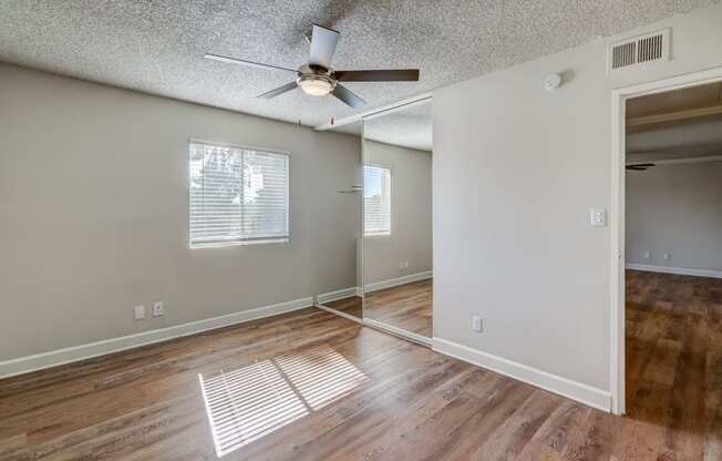 the living room and dining room of an empty house with a ceiling fan