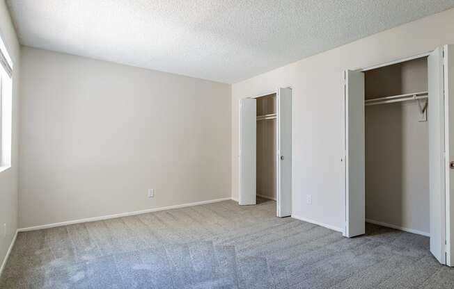 a bedroom with a carpeted floor and two closets  at Sofia Apartments, Tempe, 85283