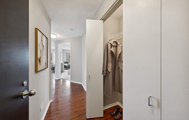 a hallway with a door to a closet with a jacket hanging on it