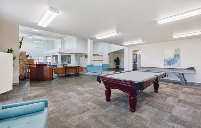 a games room with a pool table in the middle