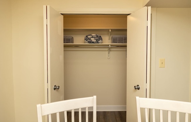A white chair is in front of a white door.