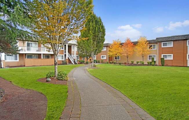 A residential area with apartment buildings and a sidewalk.