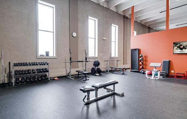 corner of fitness room with bench press and a weight rack