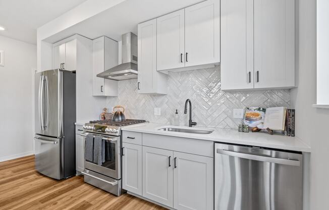 a kitchen with white cabinets and stainless steel appliances