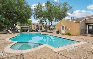 A small pool surrounded by a stone patio.