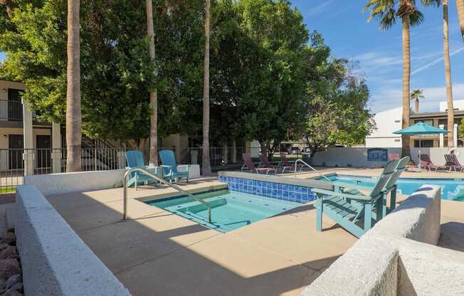 A pool surrounded by trees and chairs.