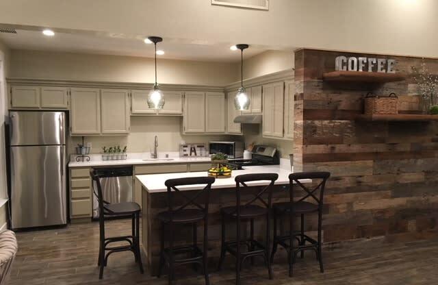 a kitchen with a bar and a table with chairs