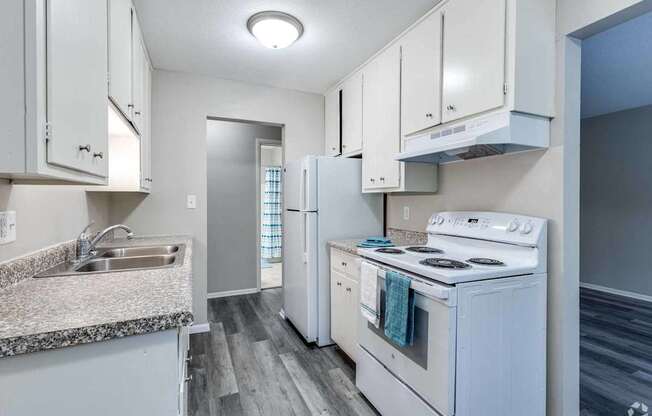 A kitchen with white appliances and cabinets.