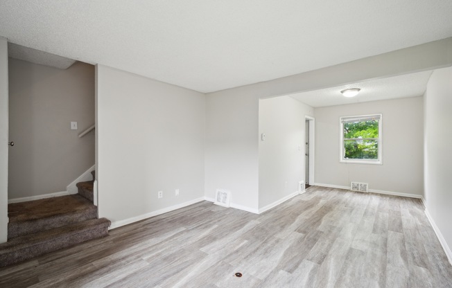 A room with a window and a door leading to a balcony.